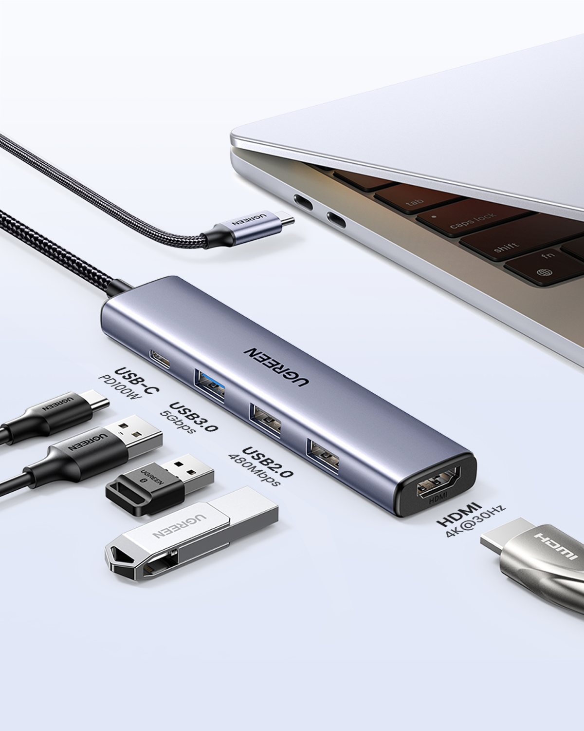 Gri USB-C hub, dizüstü bilgisayarın yanında çeşitli bağlantı noktalarına sahip.
