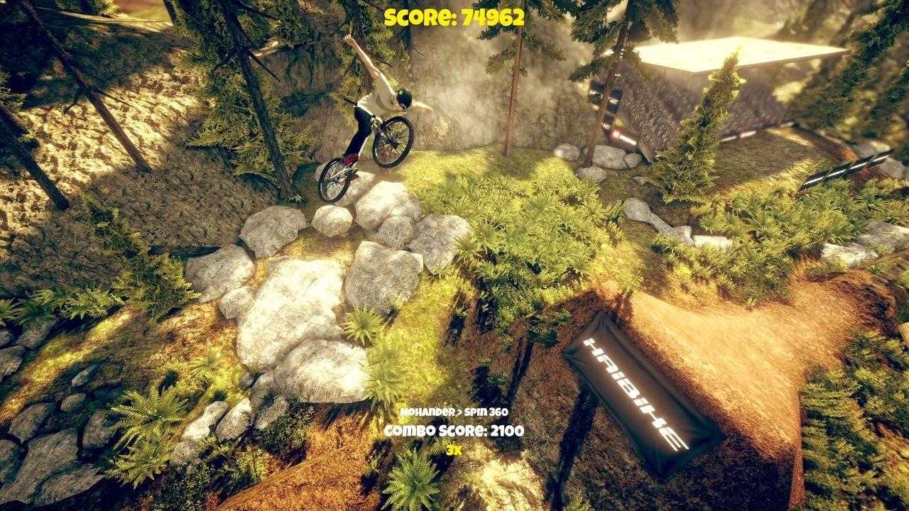 Ein Mountainbiker macht einen Sprung über Felsen und Gras in einer Waldumgebung.