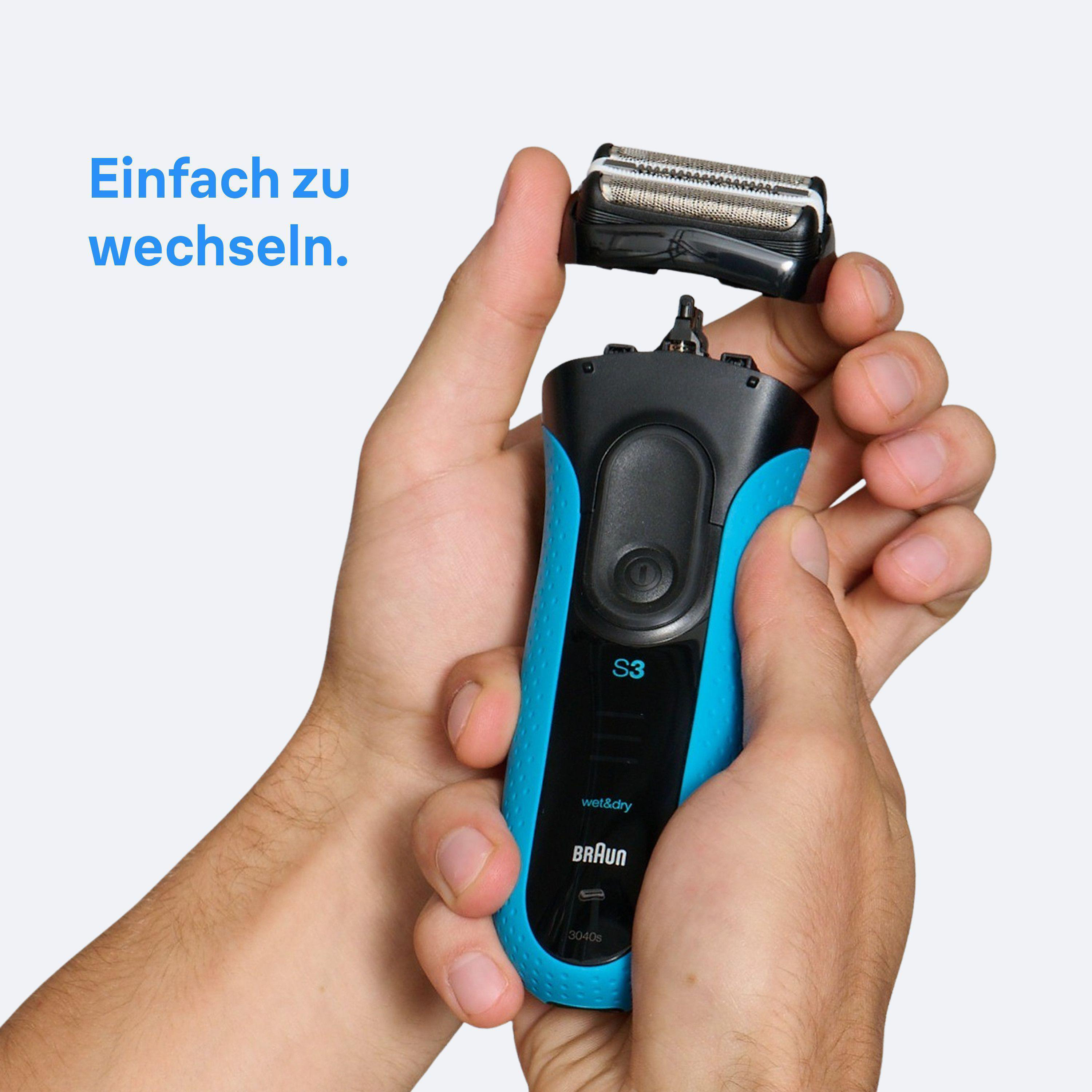 Ein Mann wechselt den Scherkopf eines blauen Braun Rasierers.