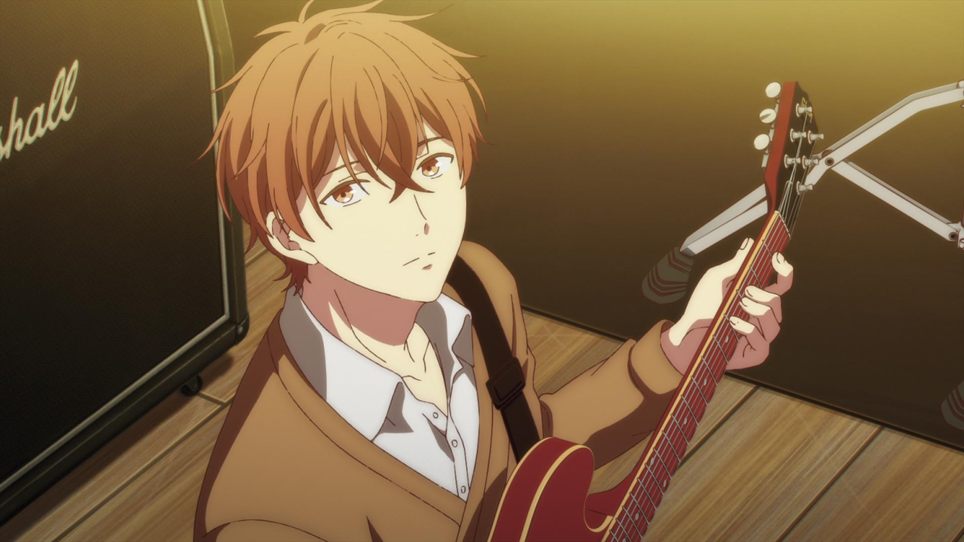 Ein Junge mit orangenem Haar spielt eine rote Gitarre neben einem Verstärker.