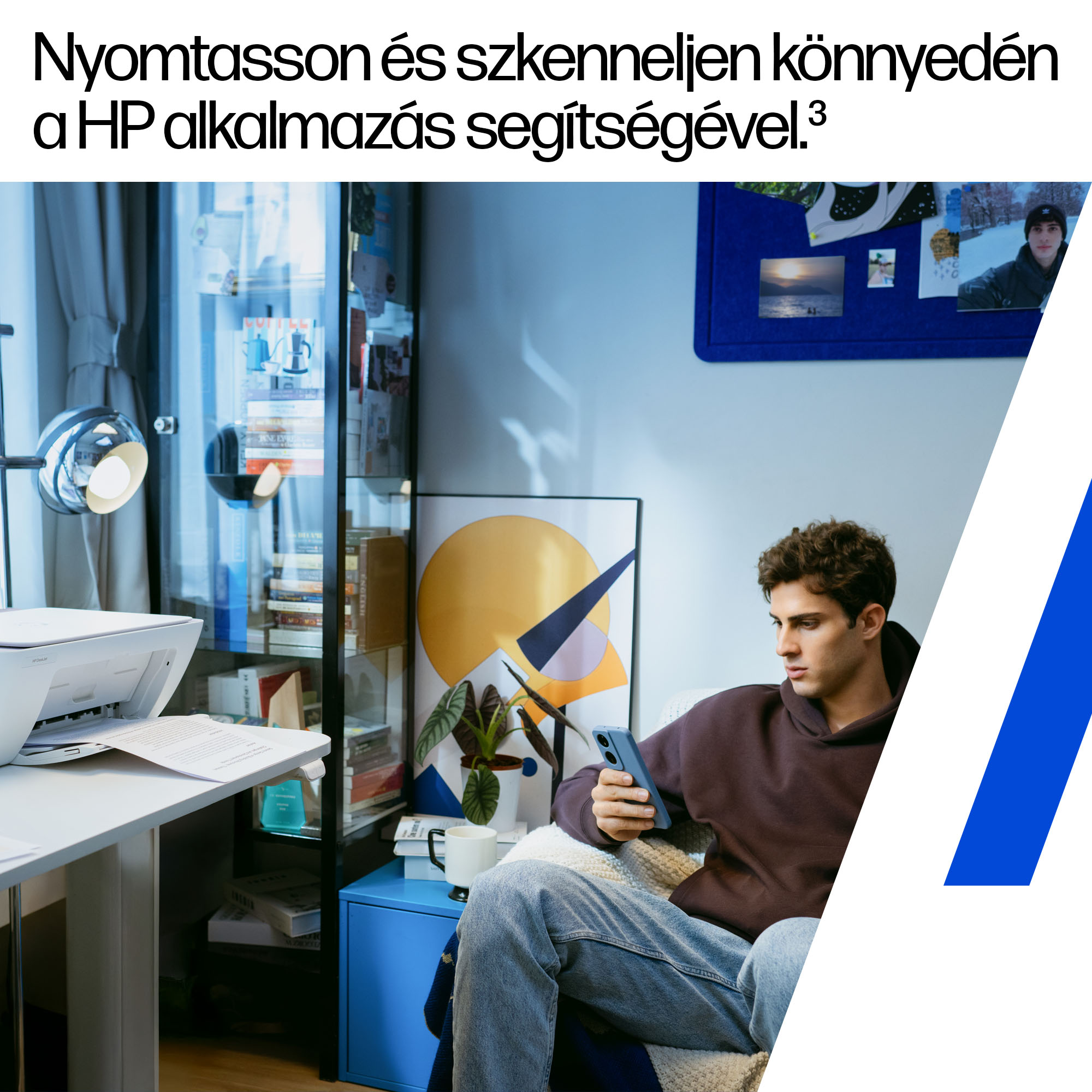 Egy férfi ül egy kanapén, telefonját nézi. Közelben egy nyomtató áll az asztalon.