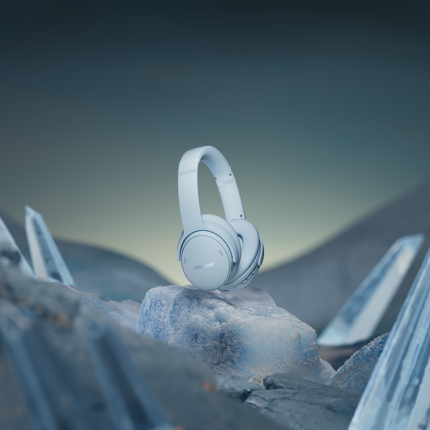 White Bose headphones on ice and snow, with icy formations in the background.