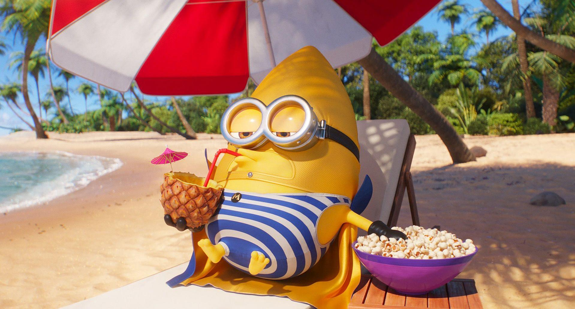 Ein Minion trinkt aus einer Ananas unter einem Sonnenschirm am Strand.