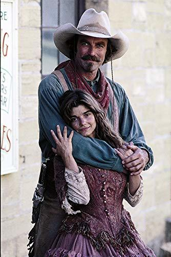 Ein Cowboy umarmt ein junges Mädchen, das sein Gesicht an seine Brust lehnt.