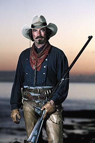 Ein Mann im Westernstil mit Hut, Halstuch und Gewehr vor einem Dämmerungshimmel.