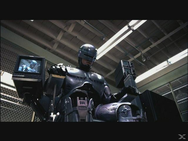 RoboCop sitzt in einem Stuhl mit einem Bildschirm, der sein Gesicht zeigt.