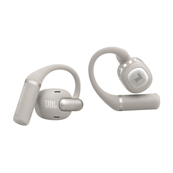 Dos auriculares JBL beige con ganchos y detalles plateados sobre fondo negro.