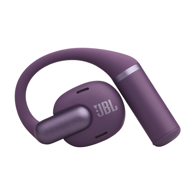 Un audífono JBL morado con gancho para la oreja está aislado sobre fondo negro.