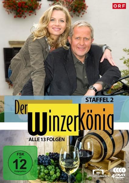 Ein Mann und eine Frau lächeln. Wein, Trauben und ein Fass sind zu sehen.