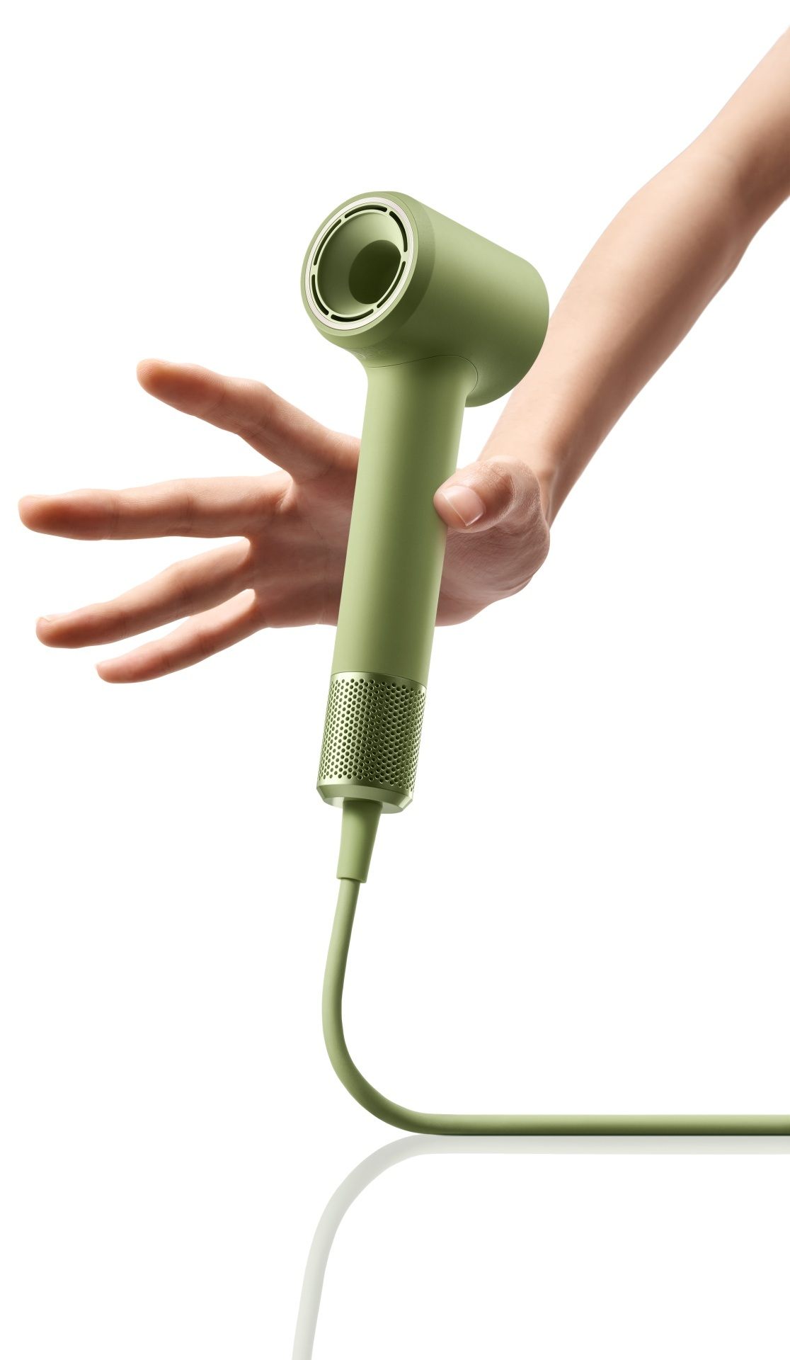 Zielona suszarka do włosów w dłoni, zbliżenie.