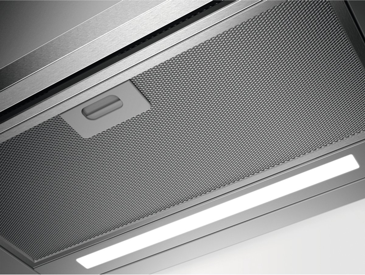 Close-up of a range hood with metal filter and LED light.