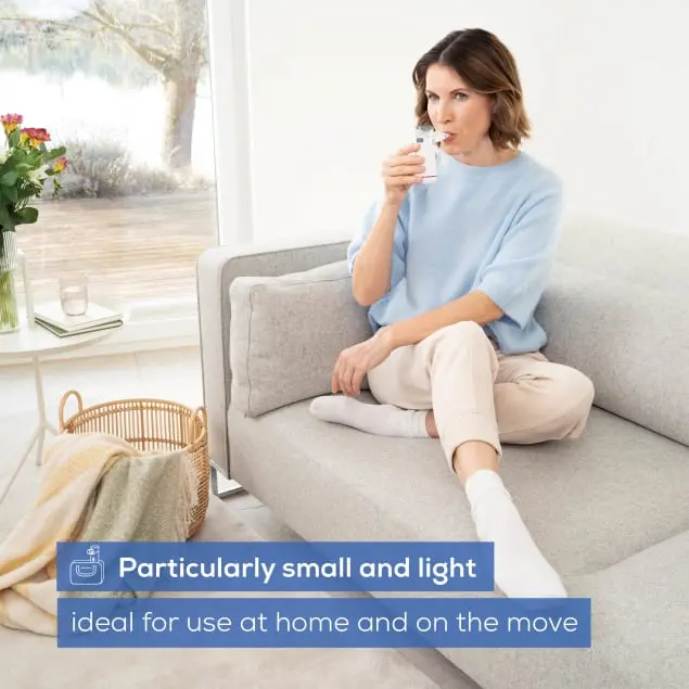 Femme assise sur un canapé utilise un inhalateur.
