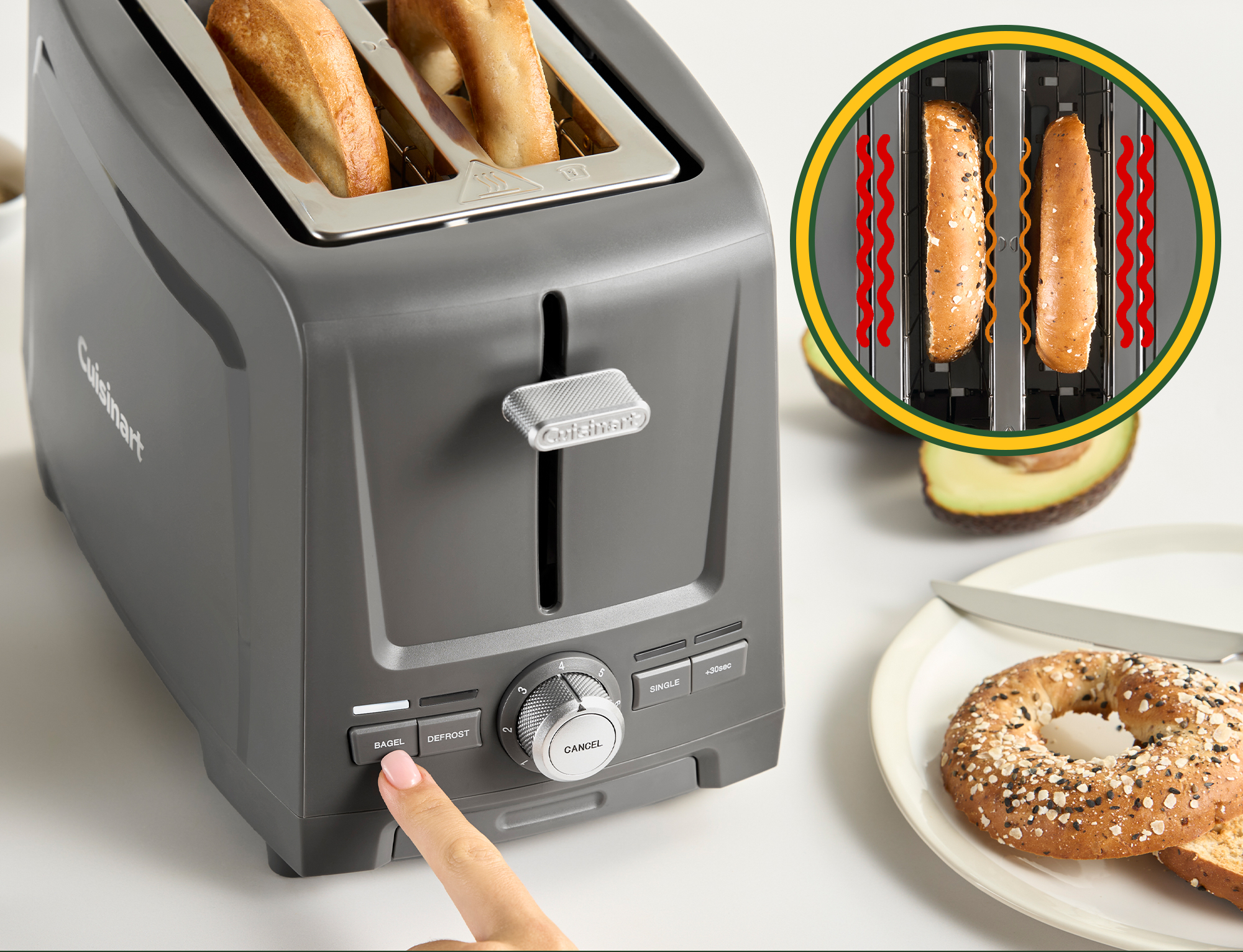 Grille-pain gris avec deux tranches de pain, un bagel sur une assiette à côté.