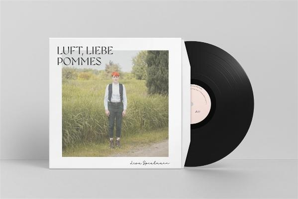Schallplatte mit Cover: Person im Feld, Titel LUFT, LIEBE POMMES.