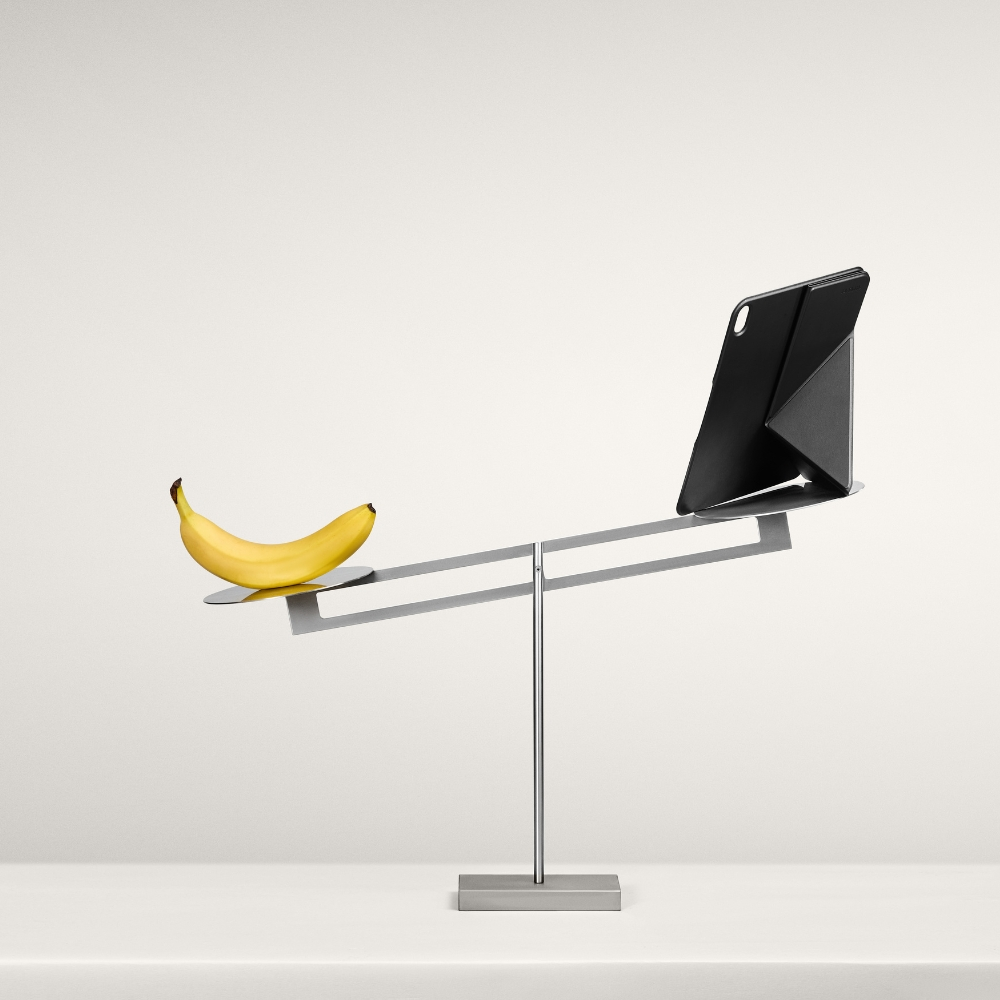 Waga z bananem po lewej i czarnym tabletem po prawej.