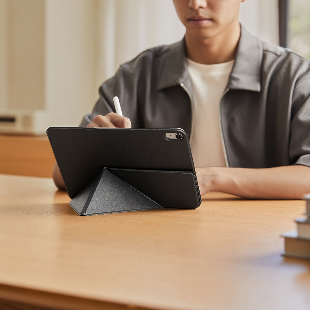 Osoba pisze na czarnym tablecie rysikiem, opartym na stojaku.