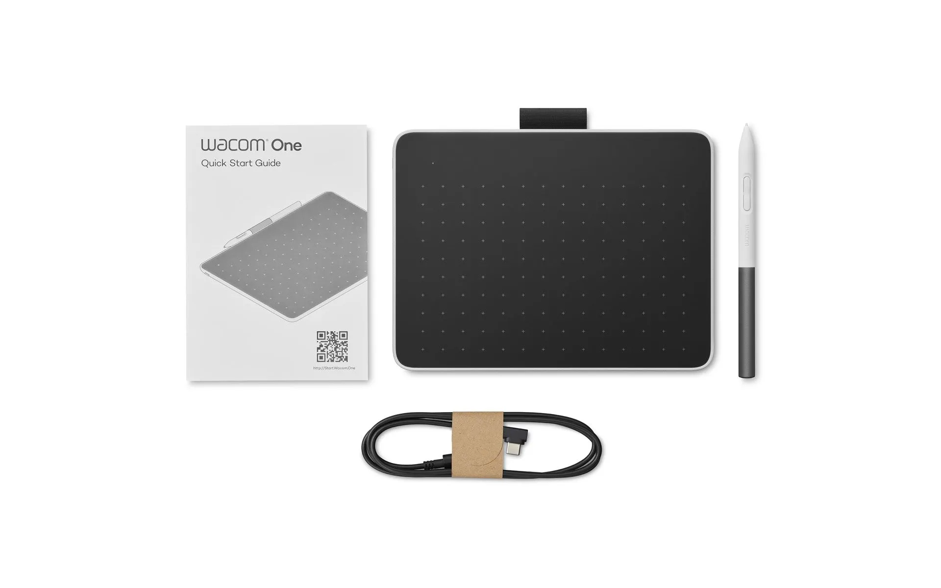 Wacom One érintőtábla, toll, kábel és gyorsindítási útmutató fehér háttéren.