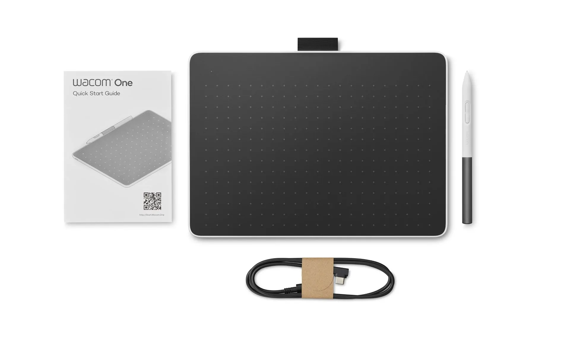 Wacom One táblagép, toll, kábel és gyorsindítási útmutató fehér háttéren.