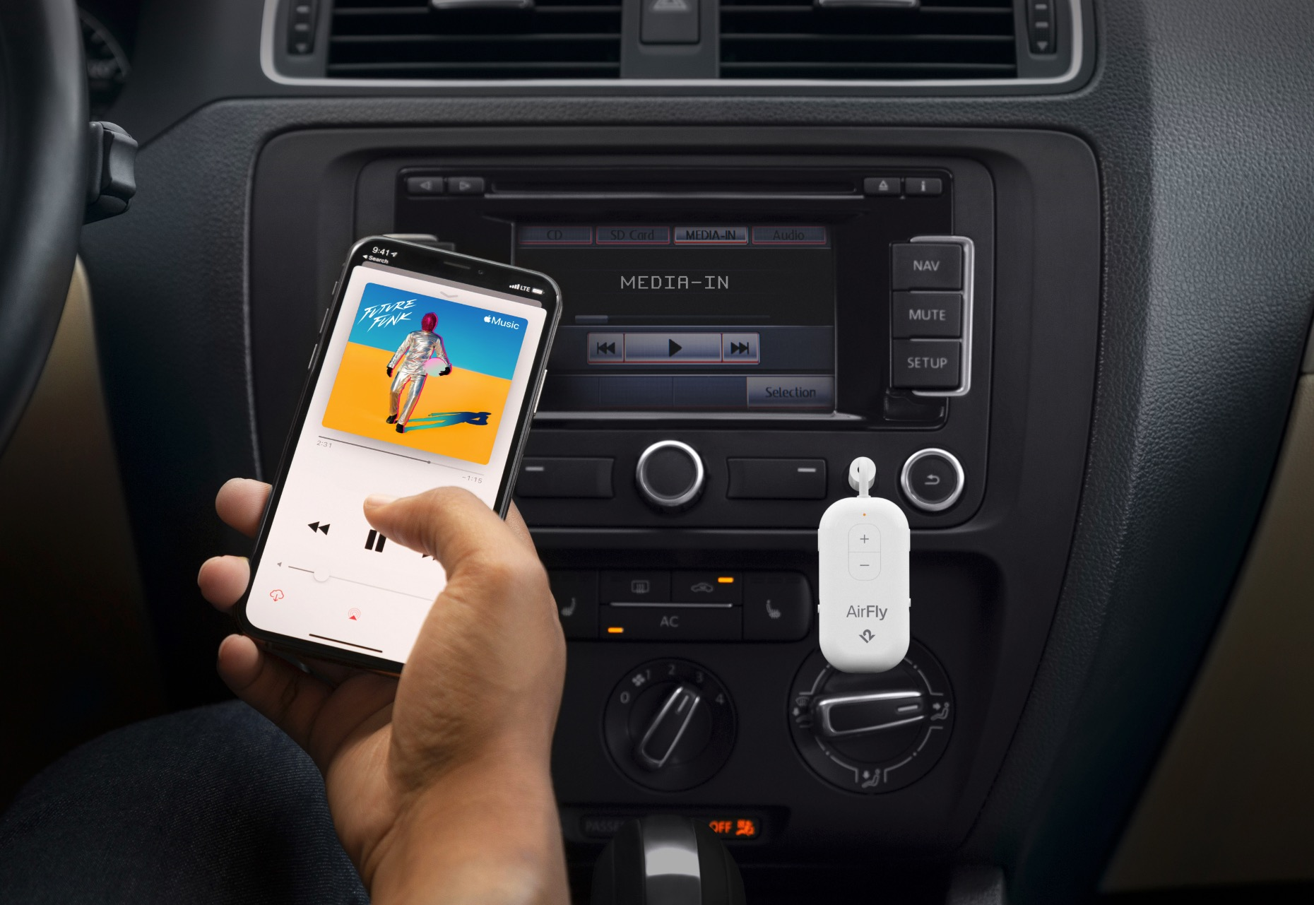 Un téléphone avec une application musicale est tenu près de la radio de voiture. Un adaptateur AirFly blanc.