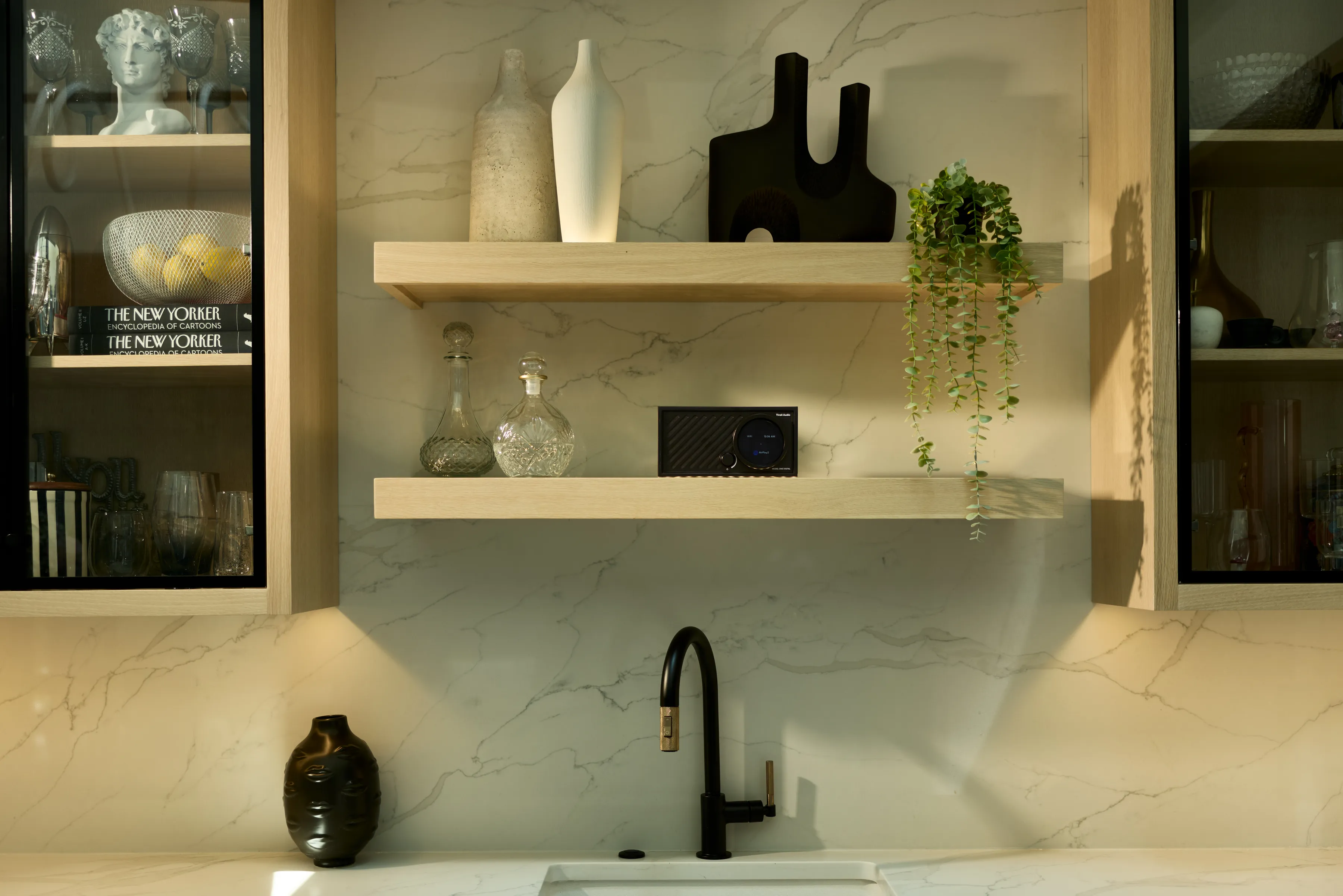 Ein moderner Küchenunterschrank mit Marmor-Rückwand, zwei Regalen und einem Wasserhahn.