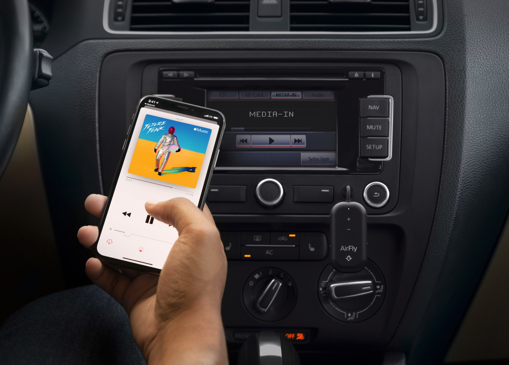 Main tenant un smartphone avec une application de musique devant la radio de voiture avec adaptateur AirFly.