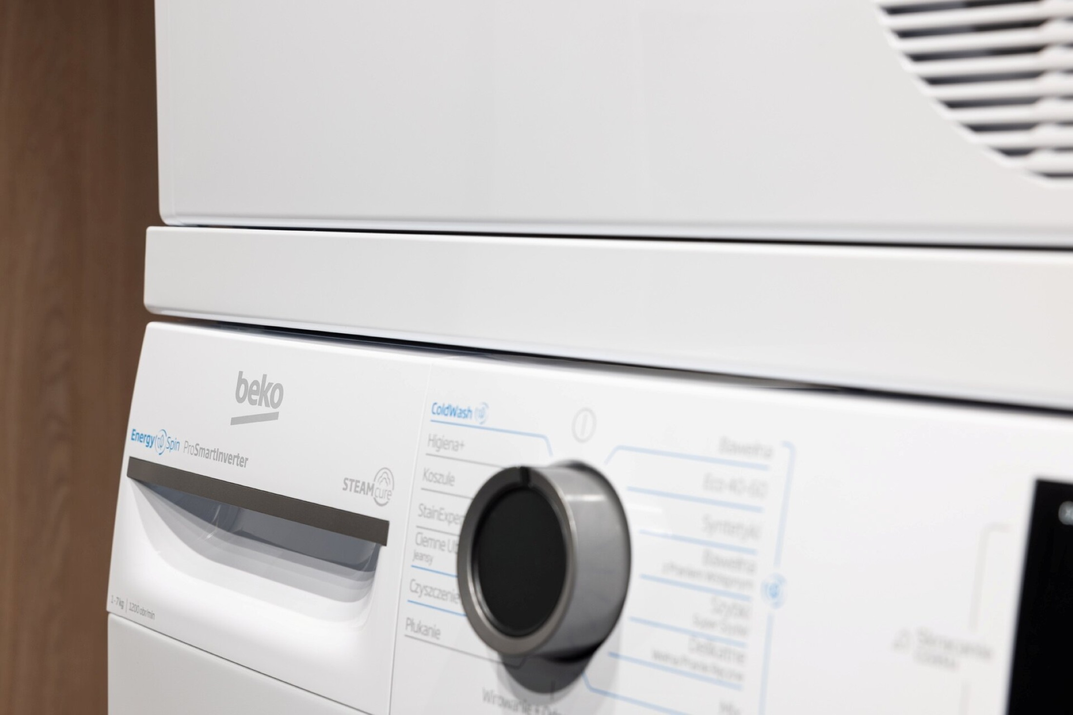 Biała pralka Beko z panelem sterowania i pokrętłem.