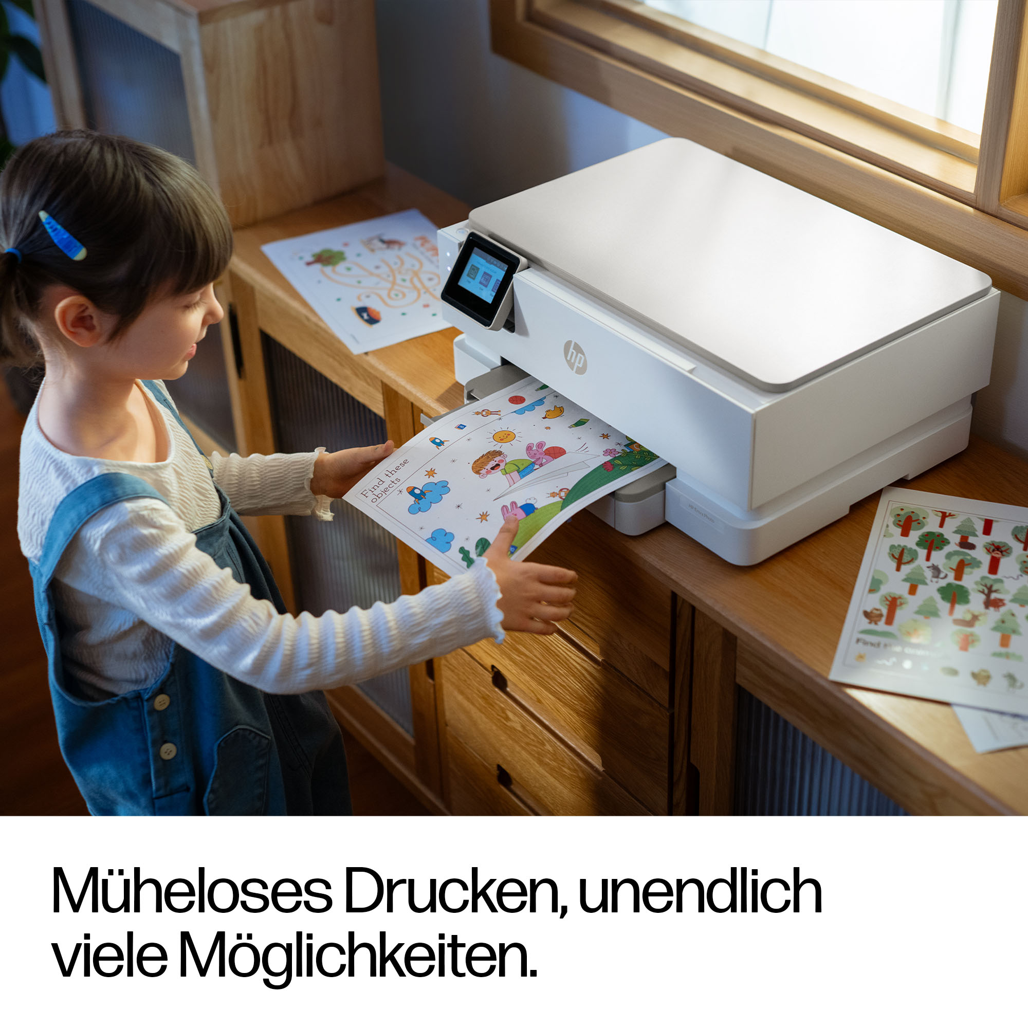 Ein Kind nimmt ein ausgedrucktes Bild aus einem Drucker.