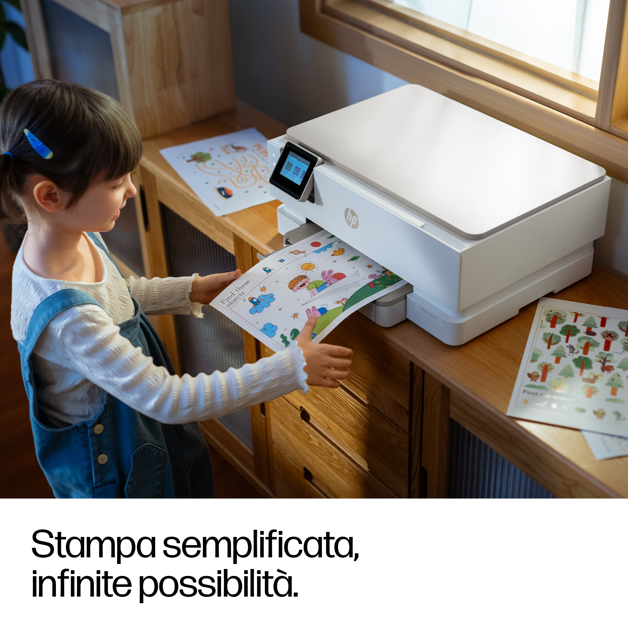 Una bambina prende un foglio di gioco stampato da una stampante.