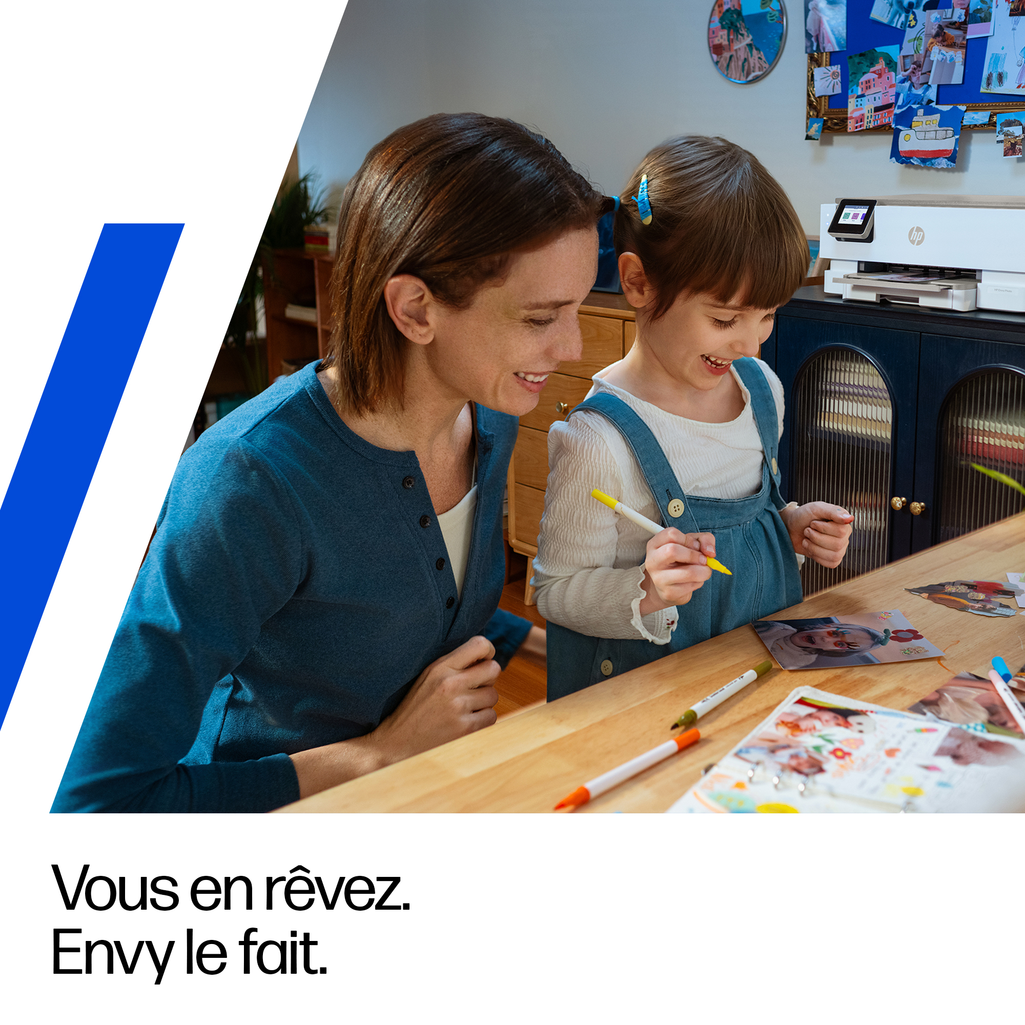 Mère et enfant bricolant avec photos et feutres sur table en bois.