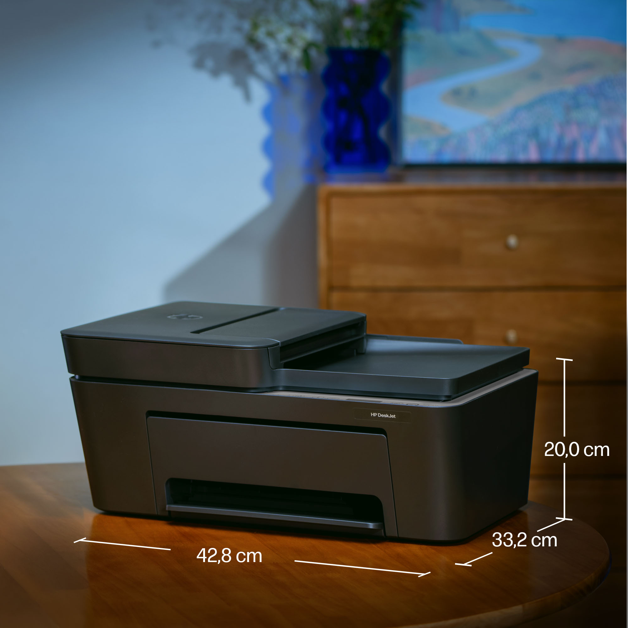 Une imprimante HP DeskJet noire de 42,8 x 33,2 x 20,0 cm sur une table en bois.