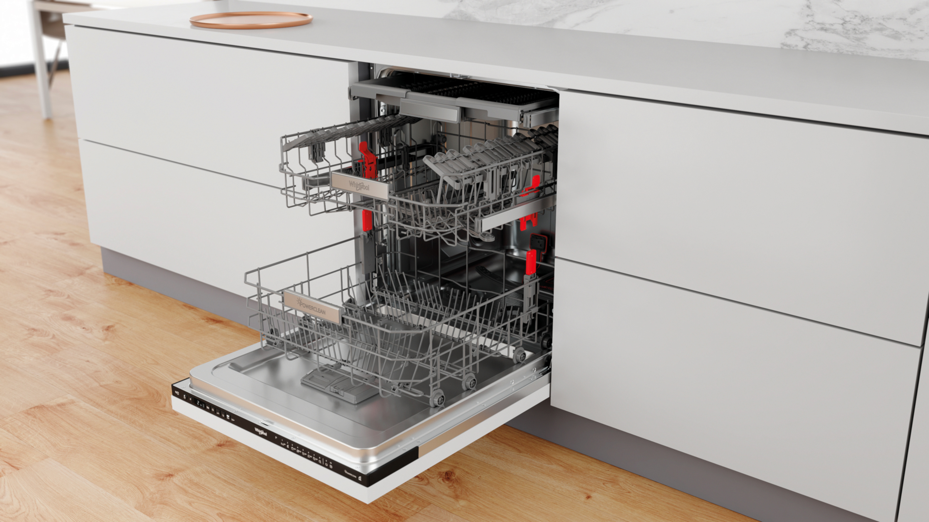 Otwarta zmywarka z dwoma koszami i szufladą na sztućce na drewnianej podłodze.