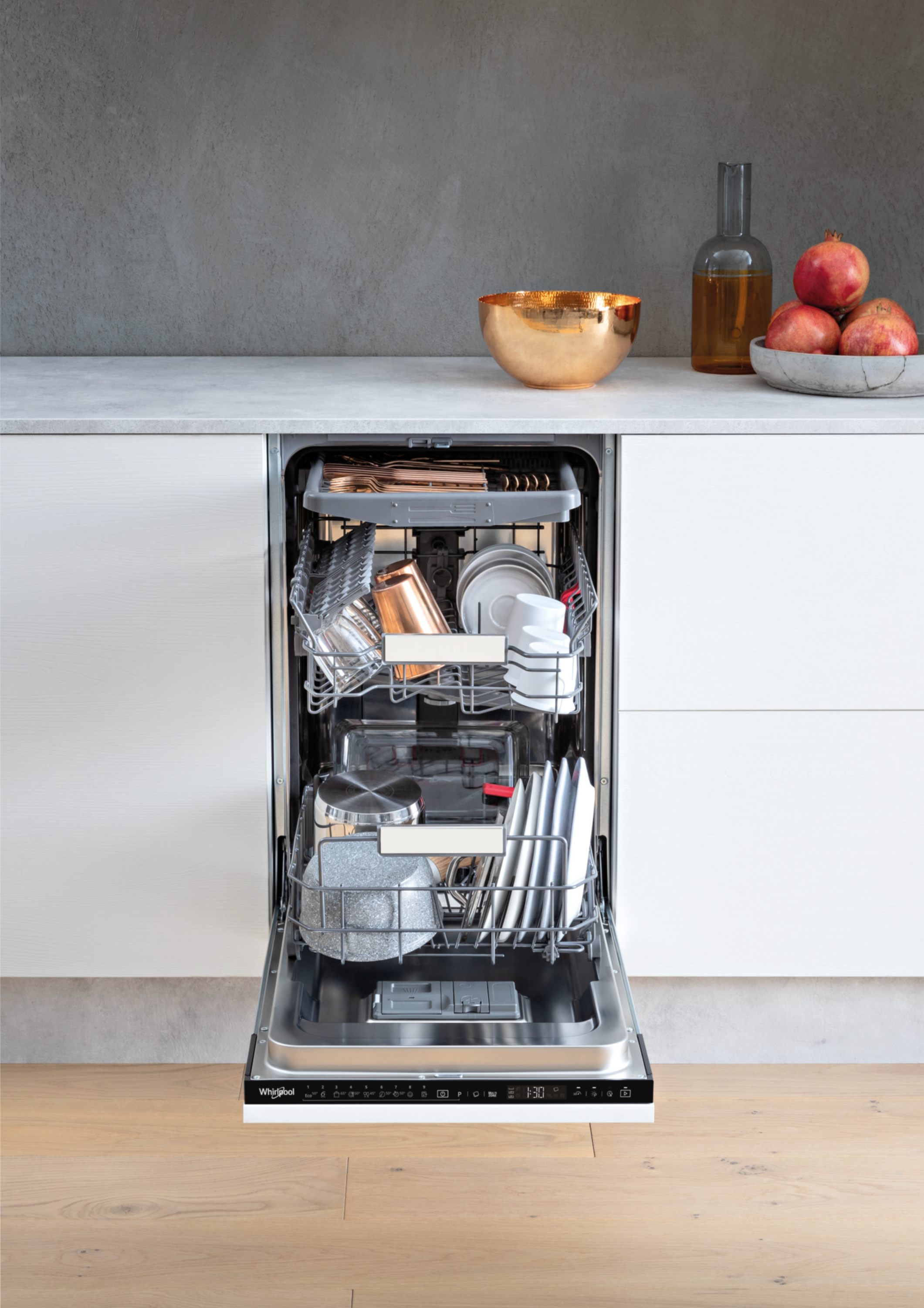 Otwarta zmywarka wypełniona naczyniami, garnkami i miedzianymi kubkami.