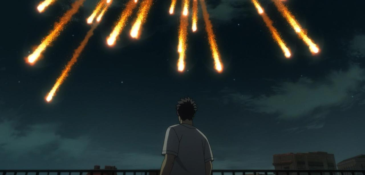 Ein Mann blickt auf einen Nachthimmel voller Feuerwerk, das von unten abgefeuert wird.