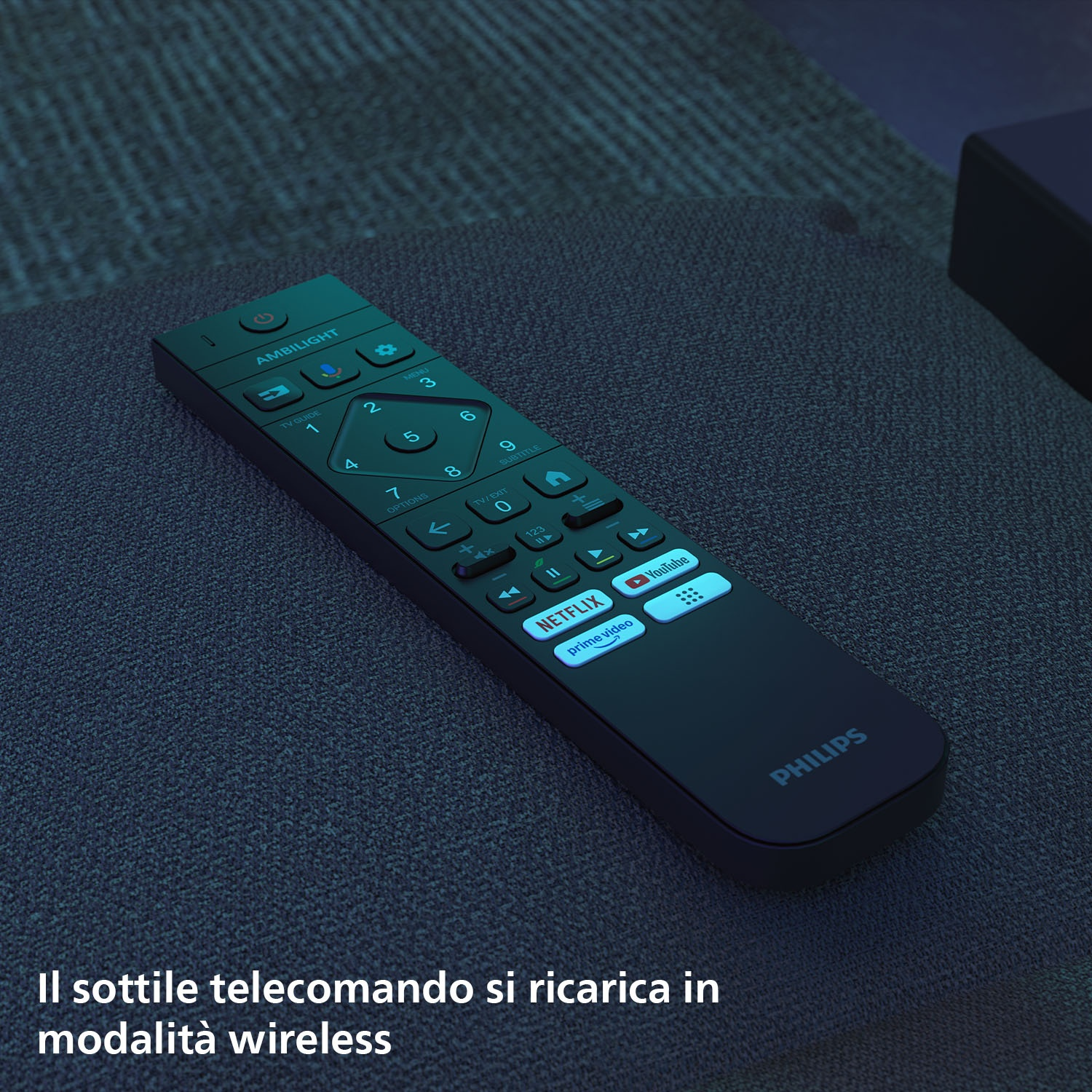 Un telecomando scuro su un divano, con logo Philips Ambilight e pulsanti.