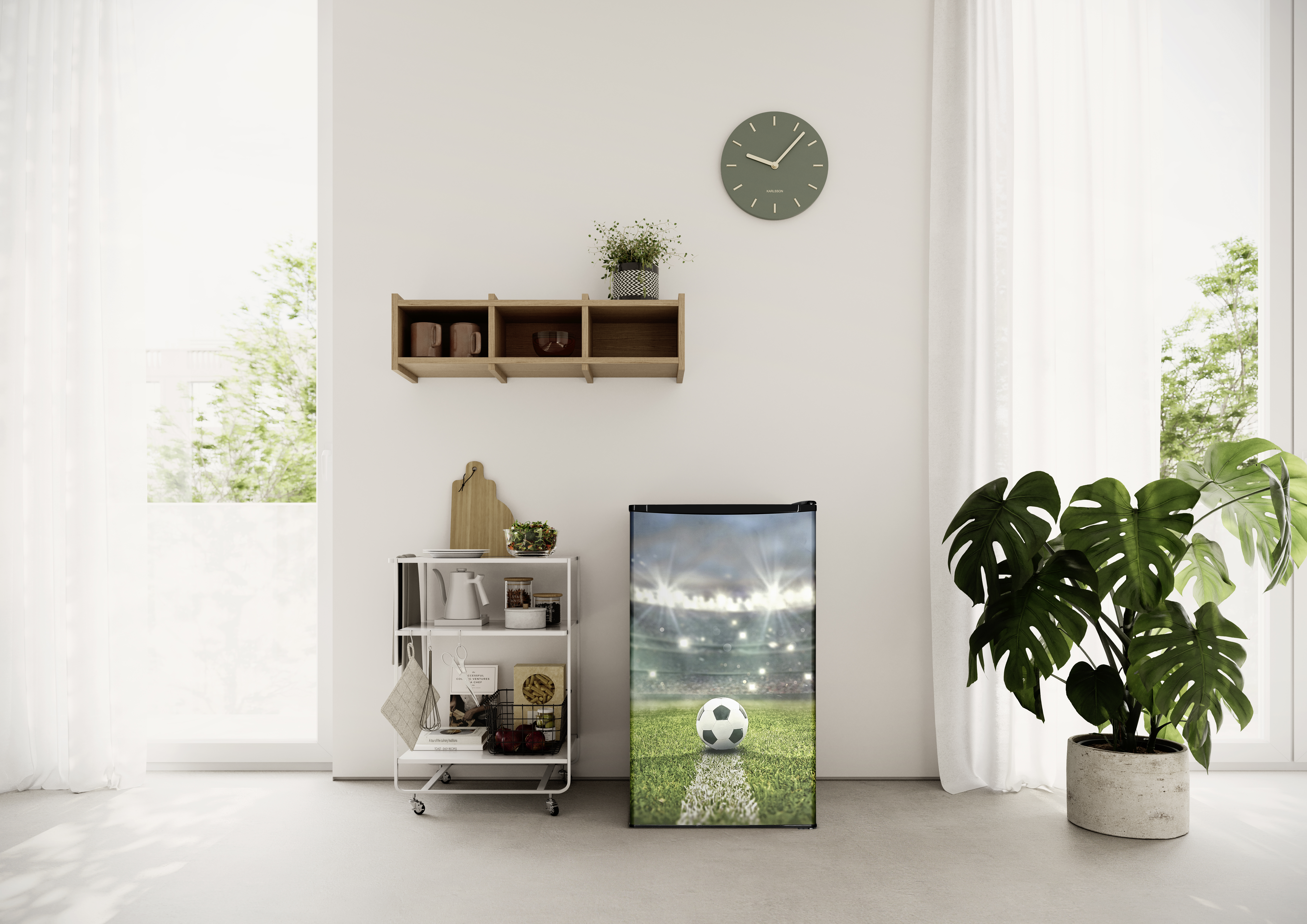 Ein kleiner Kühlschrank mit Fußballfeld-Motiv steht neben einem Pflanzenkübel.