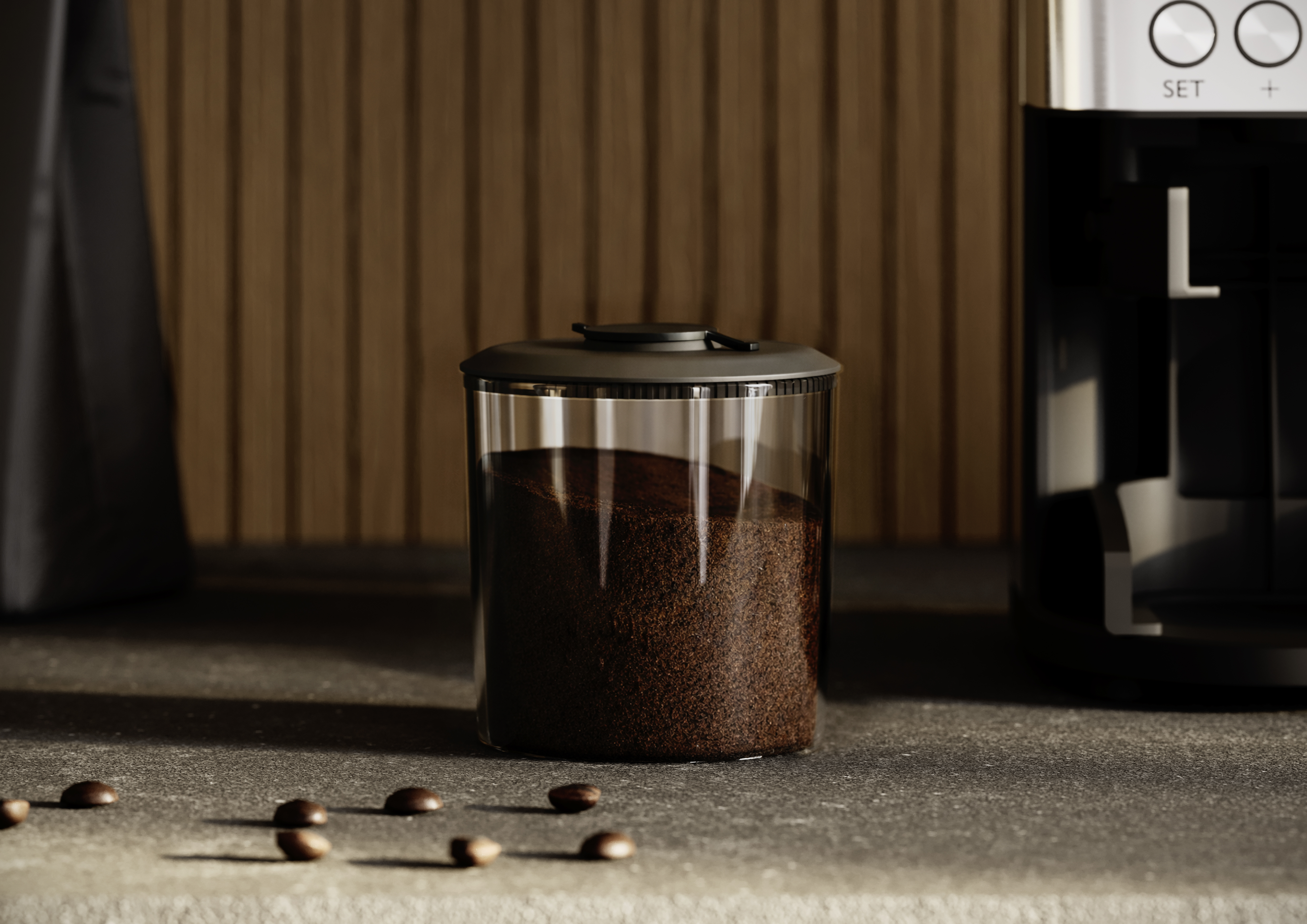 Kaffeebohnen in einem Glasbehälter neben einer Kaffeemaschine auf einer Arbeitsplatte.