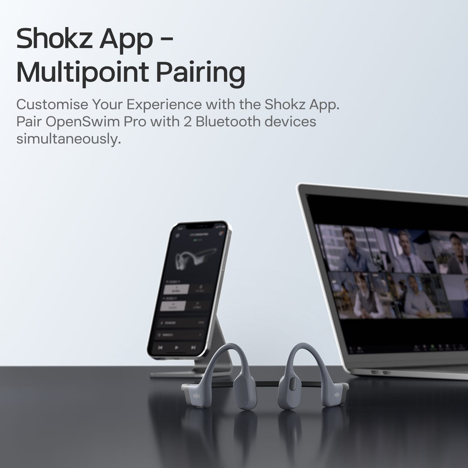 Shokz fejhallgató, okostelefon és laptop videokonferenciát mutat.
