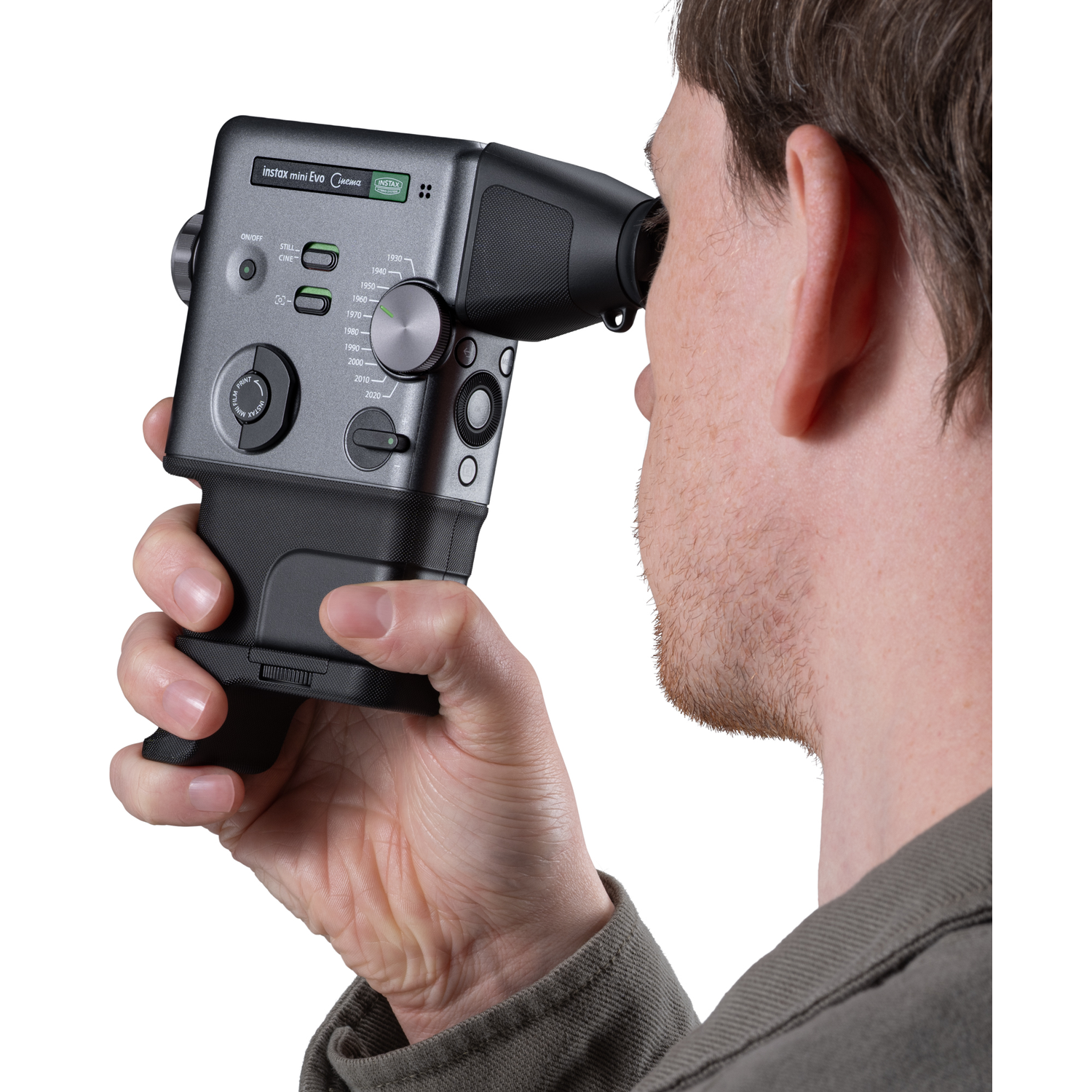 Een man houdt een grijze Instax Mini Evo camera met een zoeker voor zijn oog.