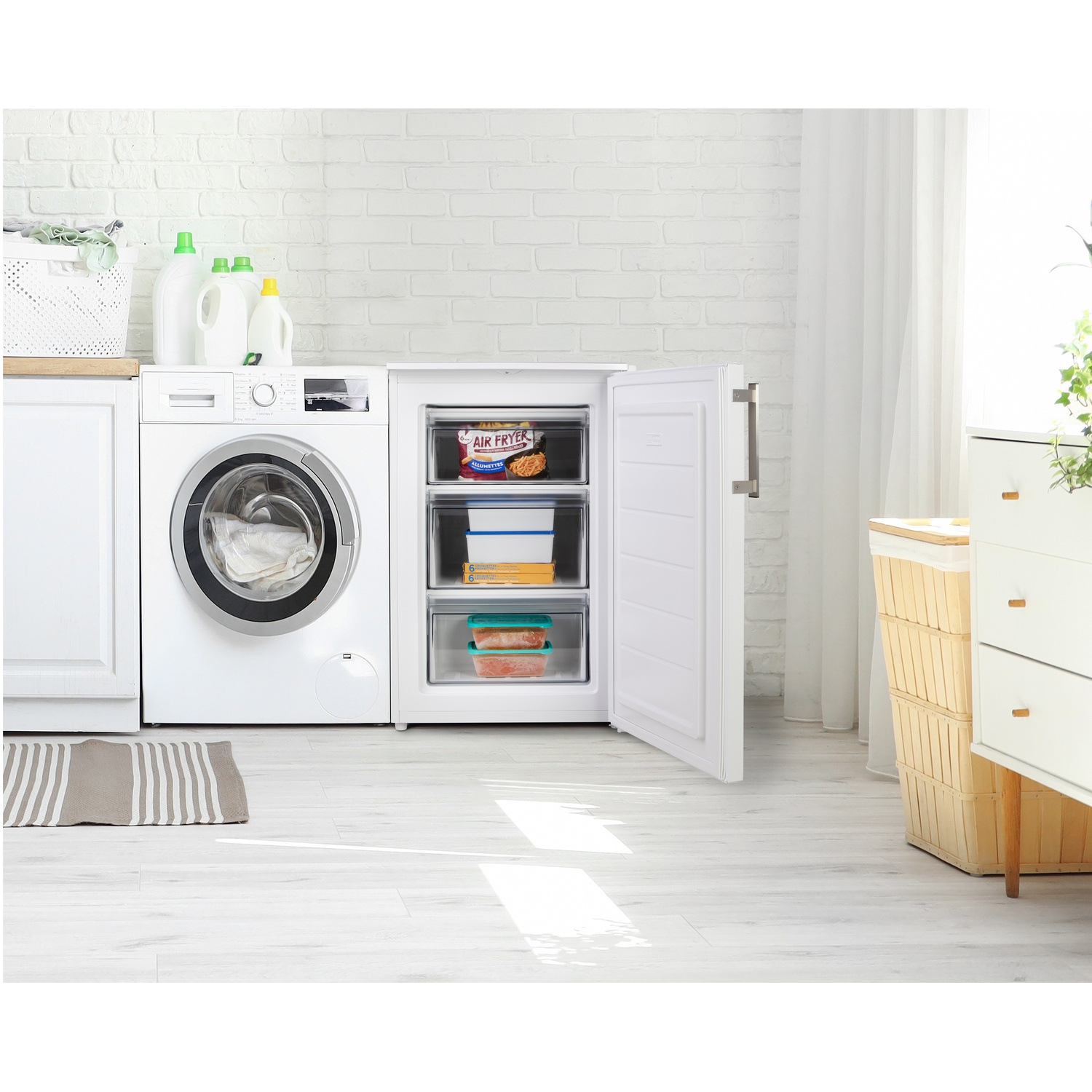 Une machine à laver blanche à côté d'un congélateur ouvert avec des aliments congelés.