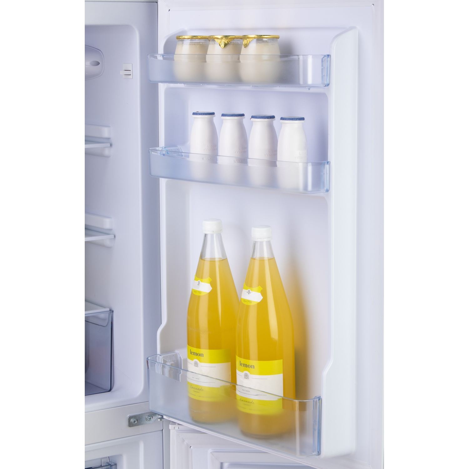 Porte de réfrigérateur avec pots de yaourt, bouteilles et limonade.