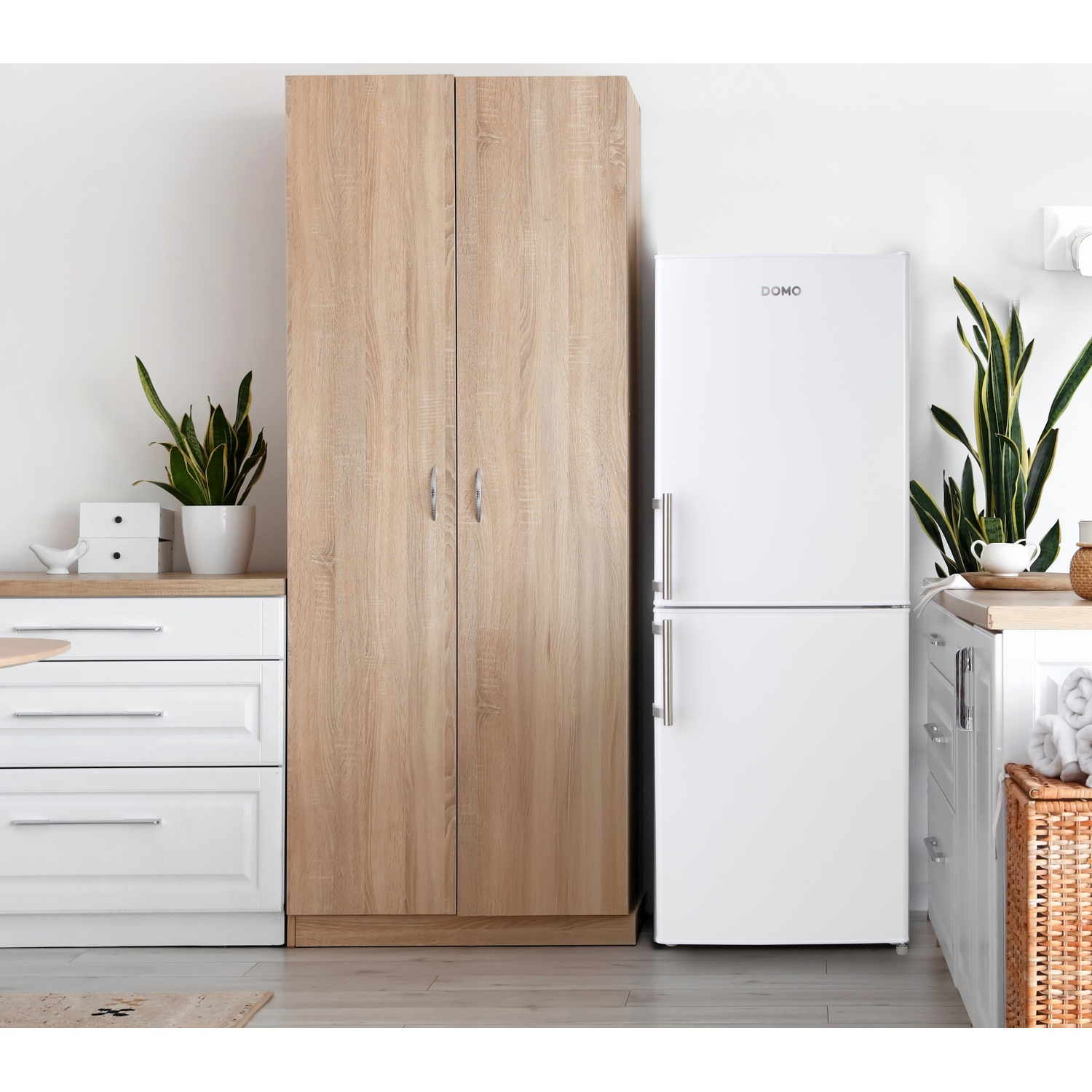 Un meuble de cuisine en bois à côté d'un réfrigérateur blanc avec des plantes.