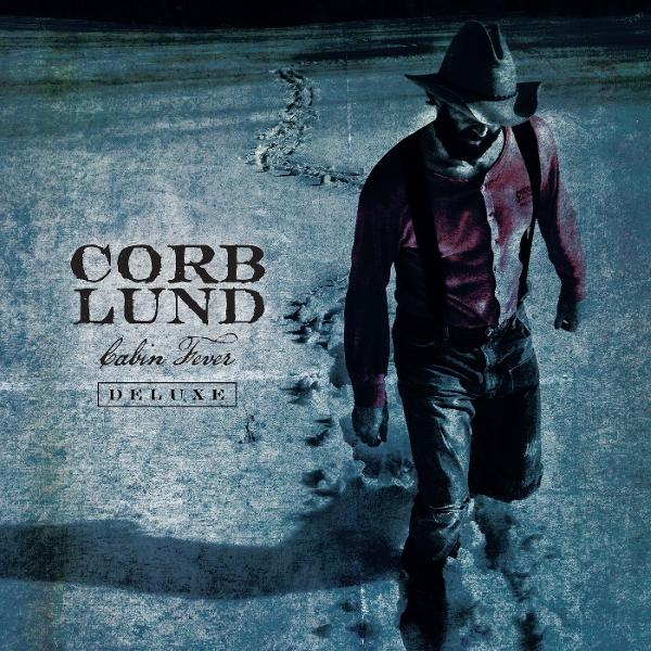 Ein Mann in einem Cowboyhut geht durch Schnee. "Corb Lund Cabin Fever Deluxe" steht links.