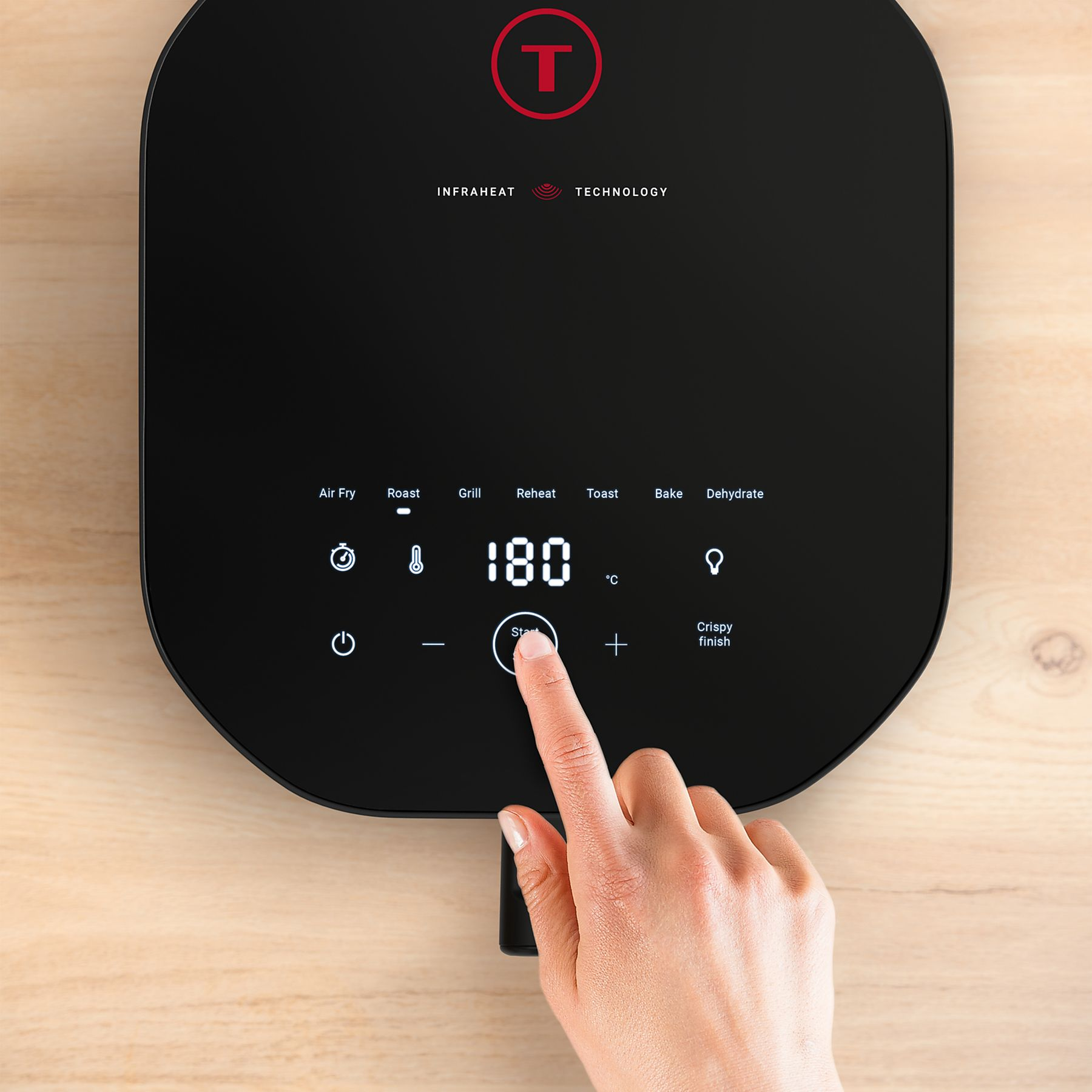 Palec naciska przycisk 'Start' na czarnym wyświetlaczu frytkownicy beztłuszczowej pokazującym 180°C.