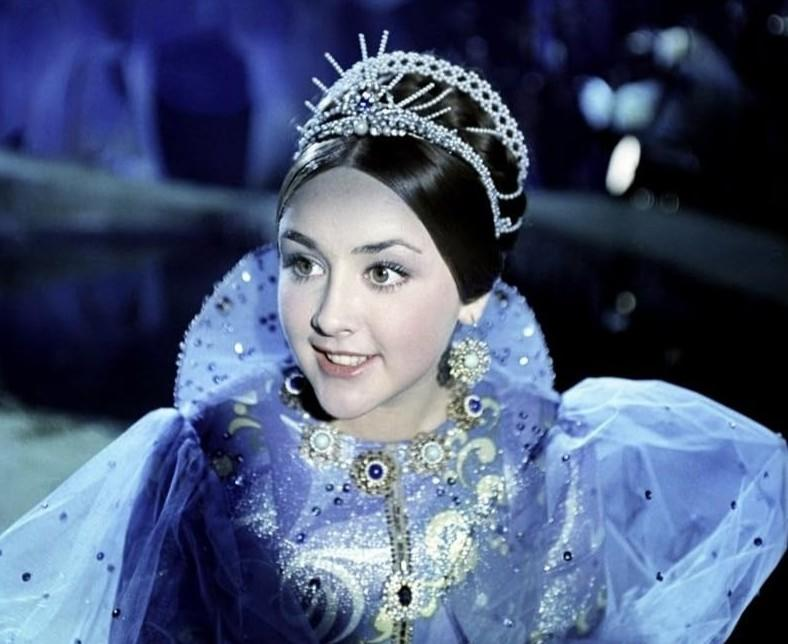Eine Frau mit Diadem und blauem, funkelndem Kleid.