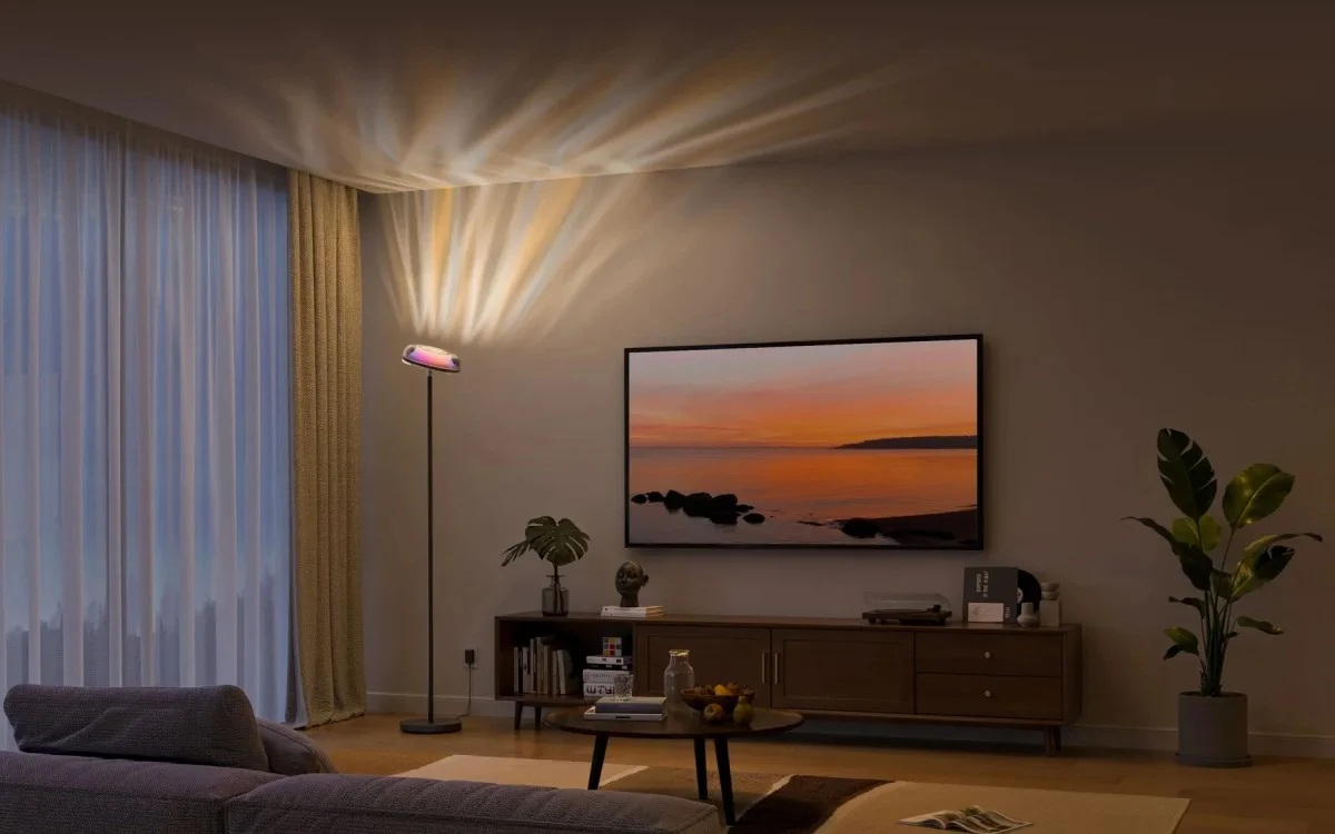 Salon z sofą, telewizorem, projektorem lampy podłogowej i zasłonami.