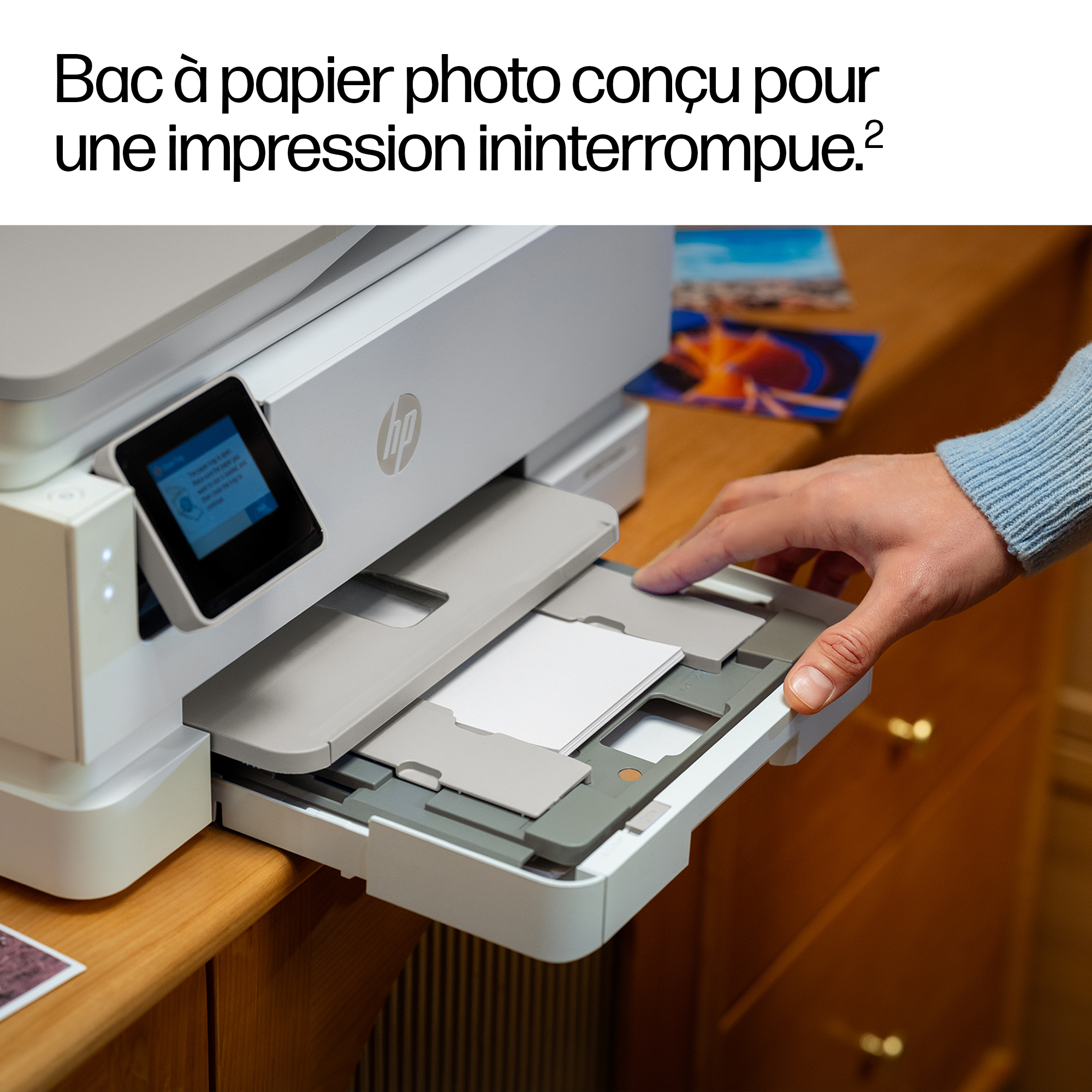 Una mano inserisce un cassetto carta in una stampante bianca. Uno schermo mostra testo.