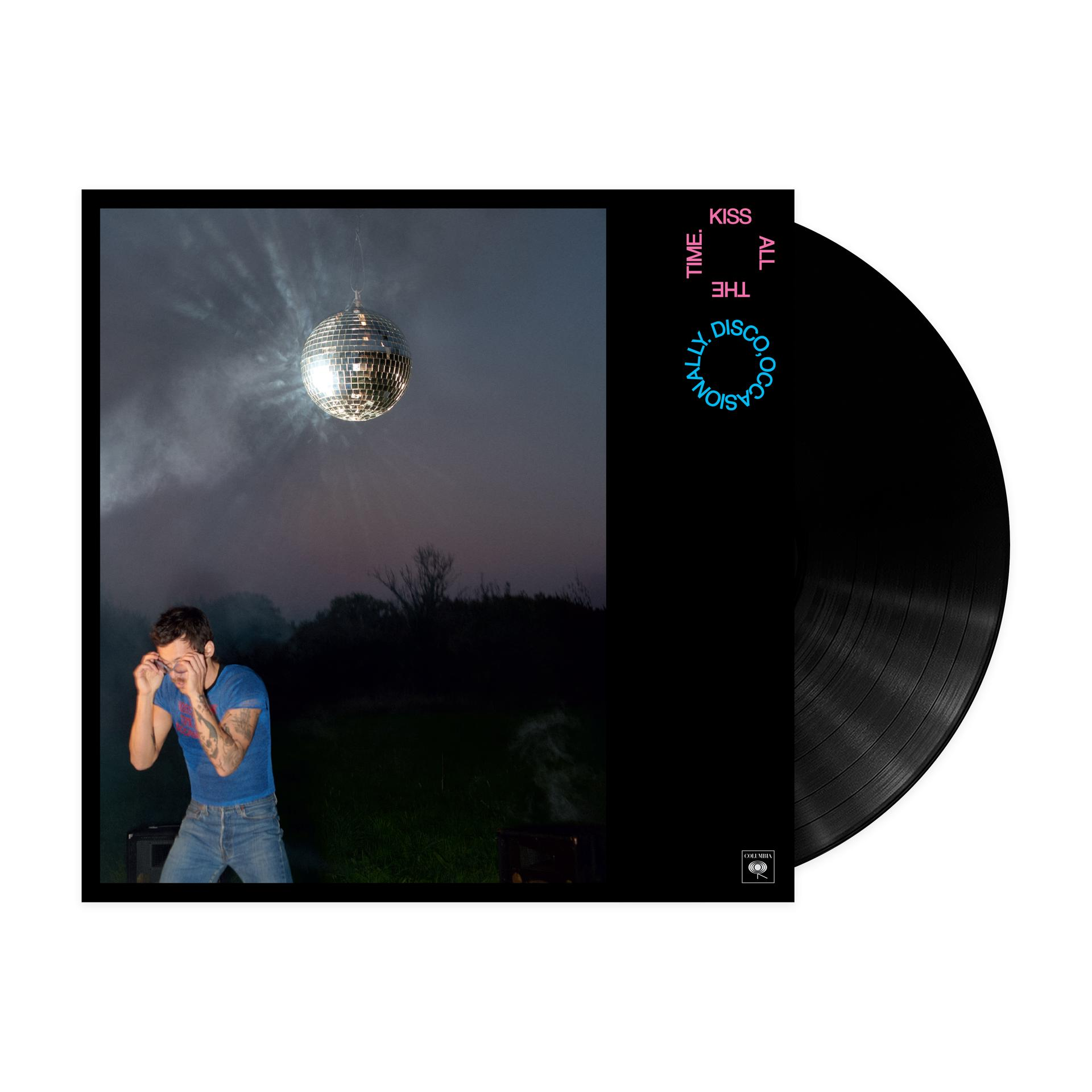Ein Mann in Jeans und blauem T-Shirt steht im Freien vor einer Discokugel und Rauch.