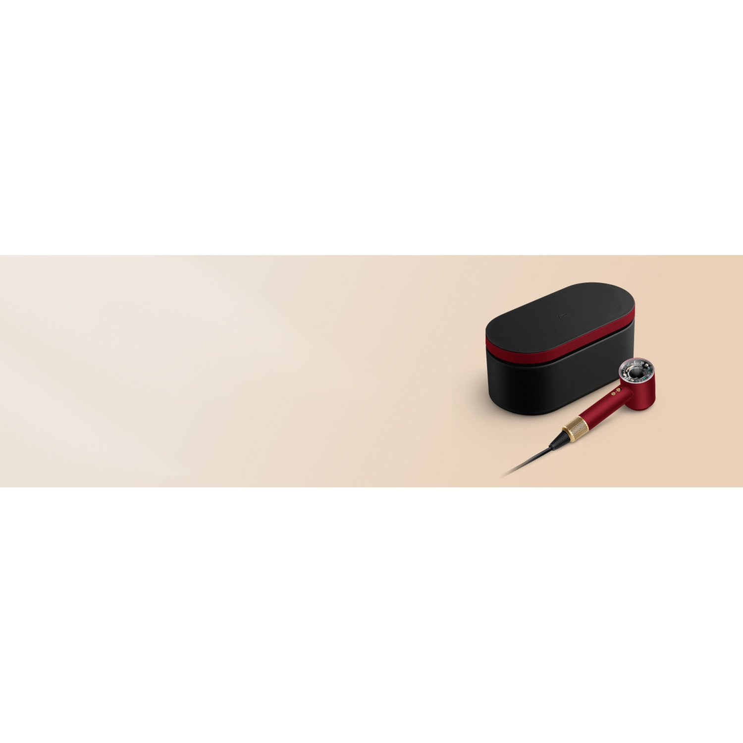 A red hair dryer lies next to a black and red storage case.