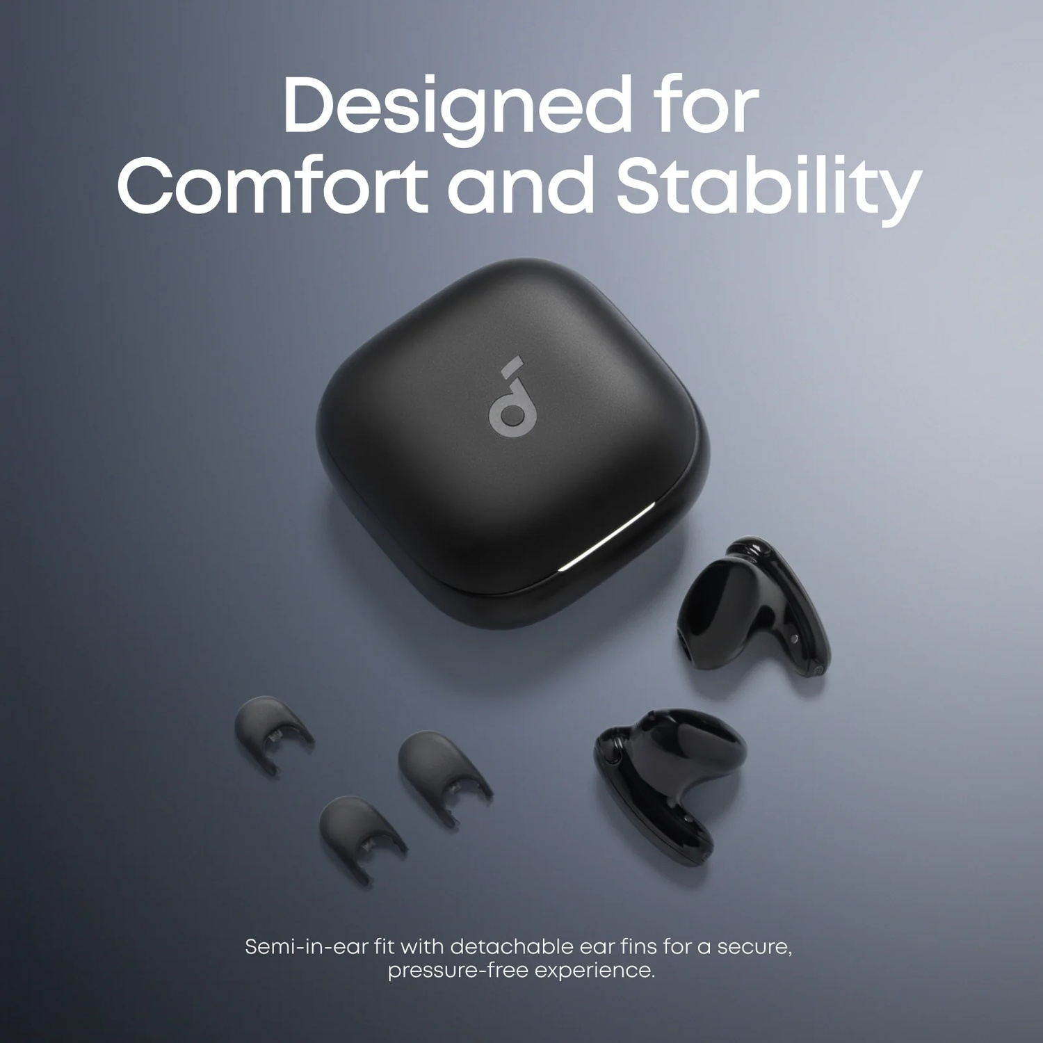 Black charging case with earbuds and ear tips on a gray background.
