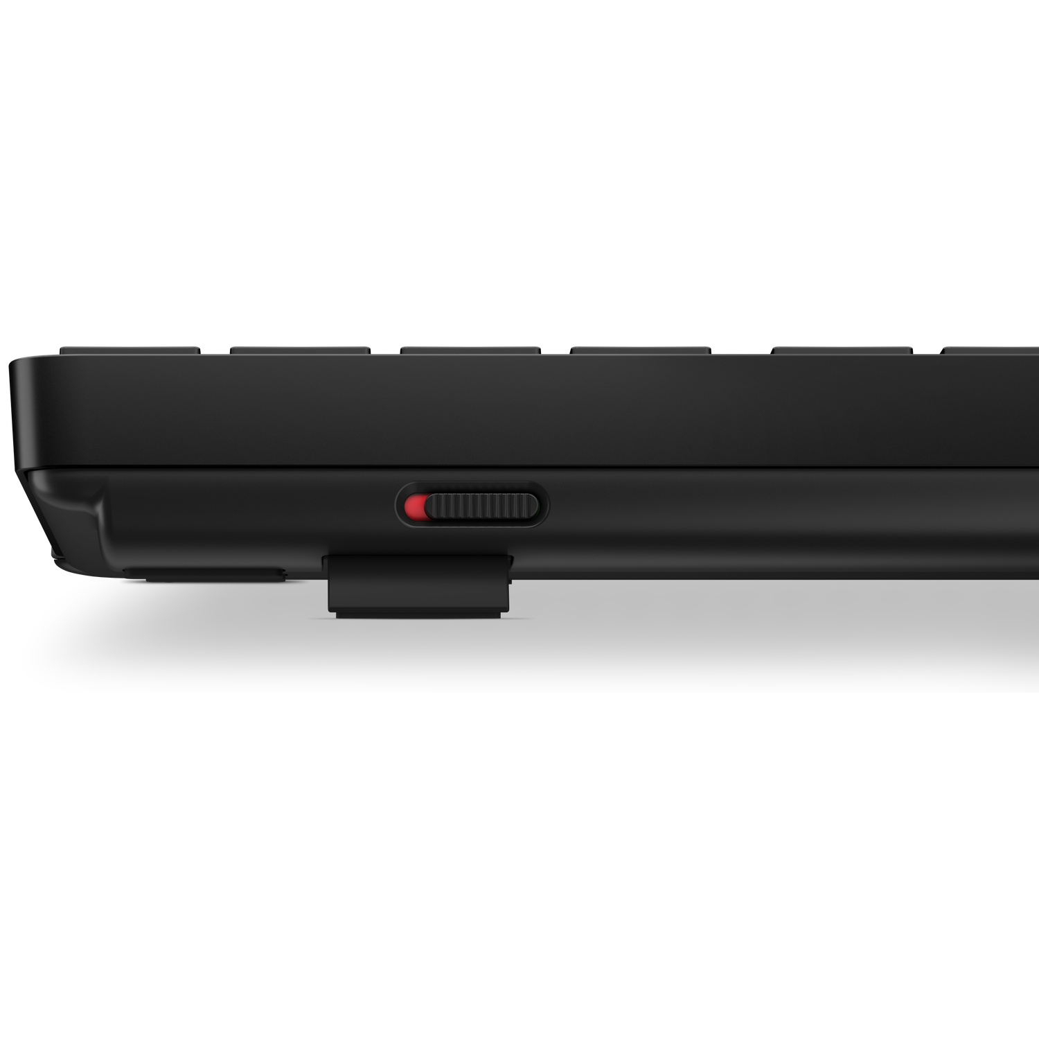Black keyboard profile view with red switch and black USB dongle.